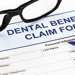 Dental benefits claim form with pen and glasses