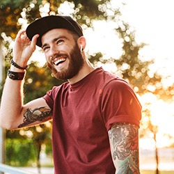 Man with hat standing outside and smiling