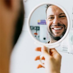 Man checking his smile in the mirror