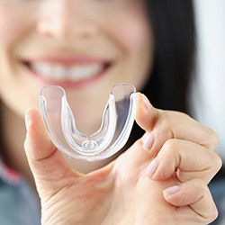 Woman holding up an athletic mouthguard