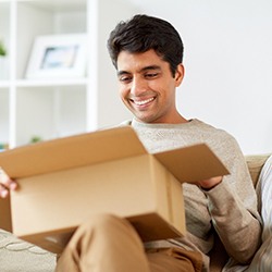 Man sitting on couch with an open box