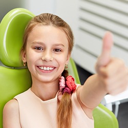 Smiling child giving thumbs up