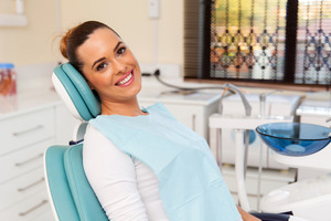 Dental patient sitting in chair and smiling